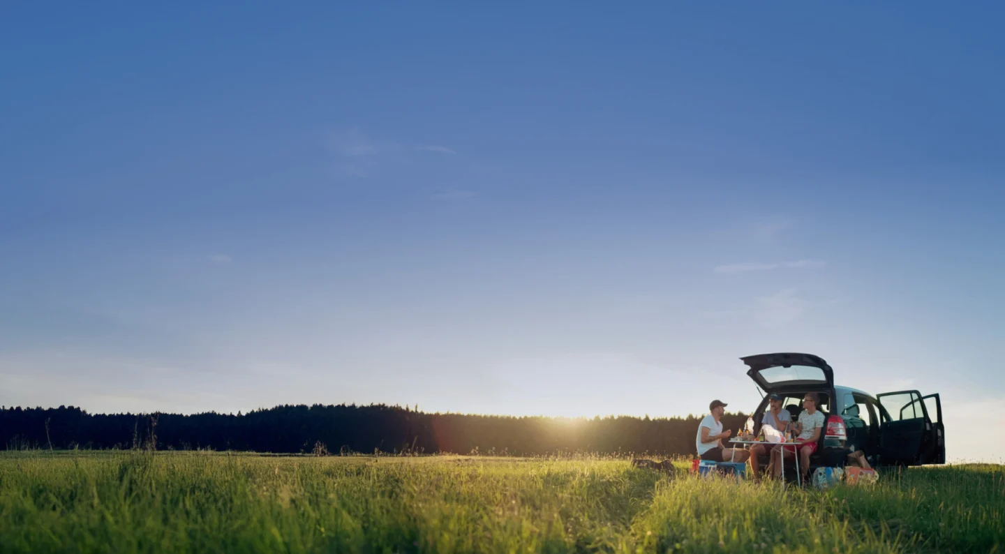 Picnic by the car on a green meadow