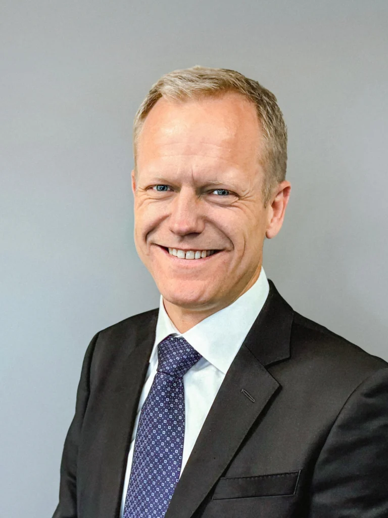 Leende man i kostym och slips