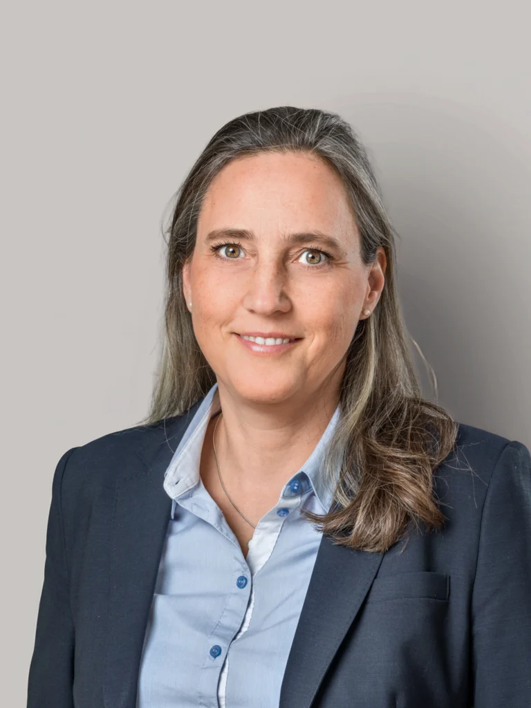 Kvinna i kostym och blå skjorta, porträttfoto.